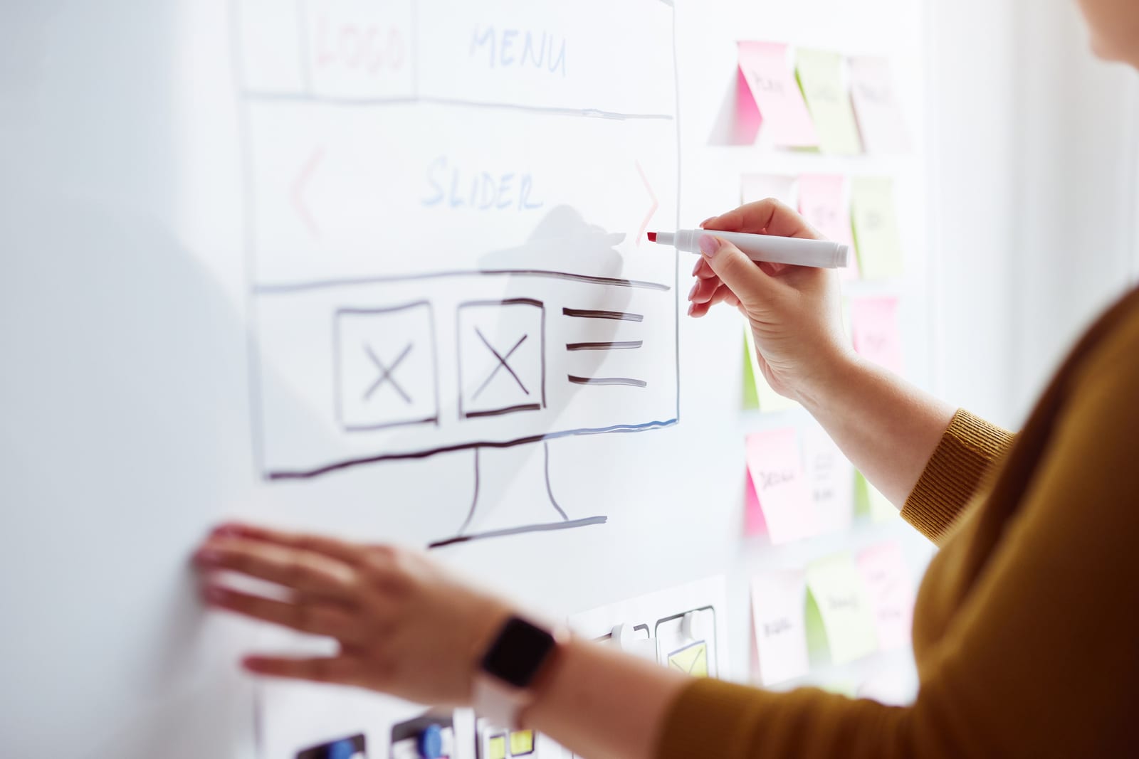 Workflow planning on office glass, colored sticky notes with the word Agile and a rocket symbol