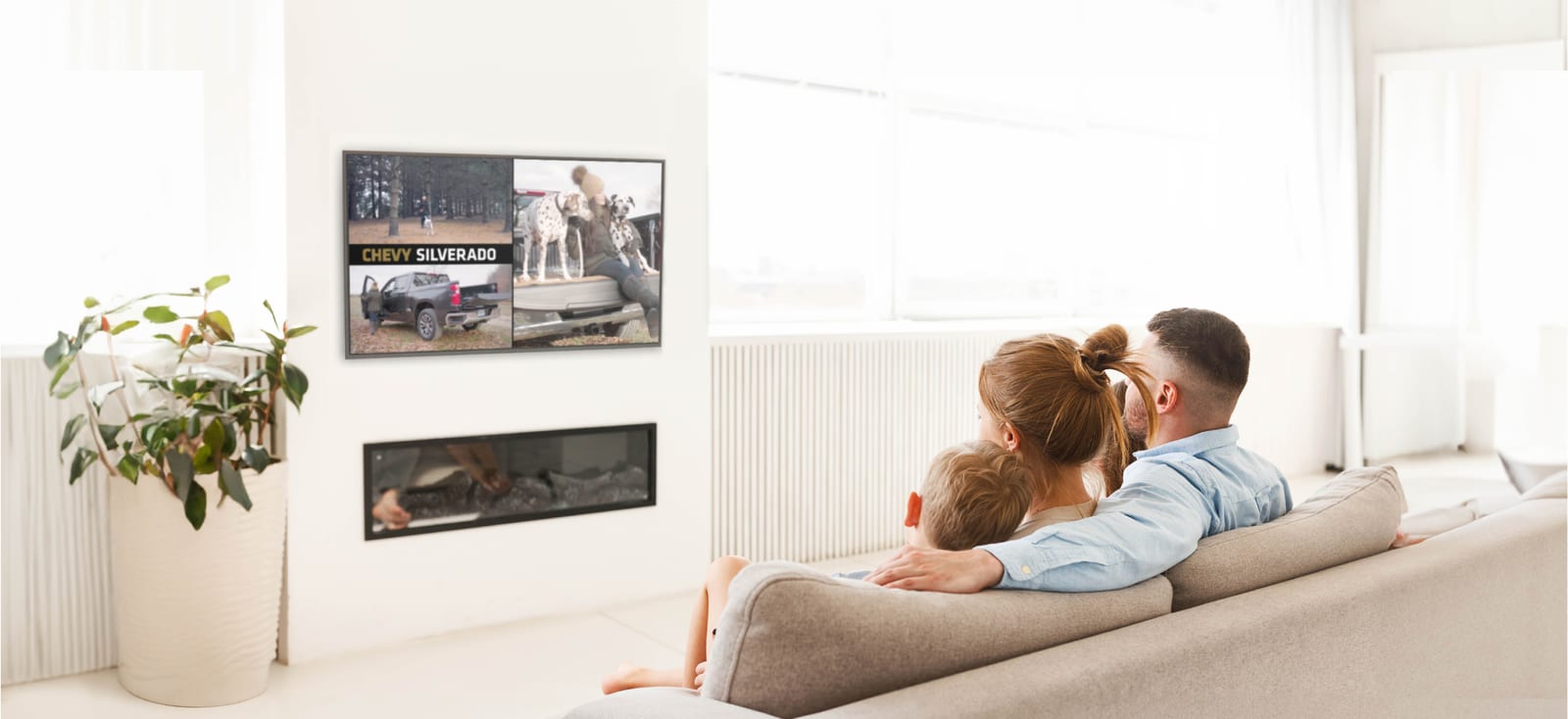 family gathered on a couch to view a tv with a silverado advertisement from metro detroit chevy dealers for Personalized Automotive Marketing